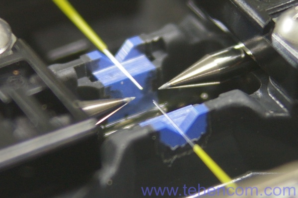 This photo shows two optical fibers installed in the fixed V-grooves of the Fujikura 12S. Fujikura 12S Fiber Optic Splicer Fixed V Groove